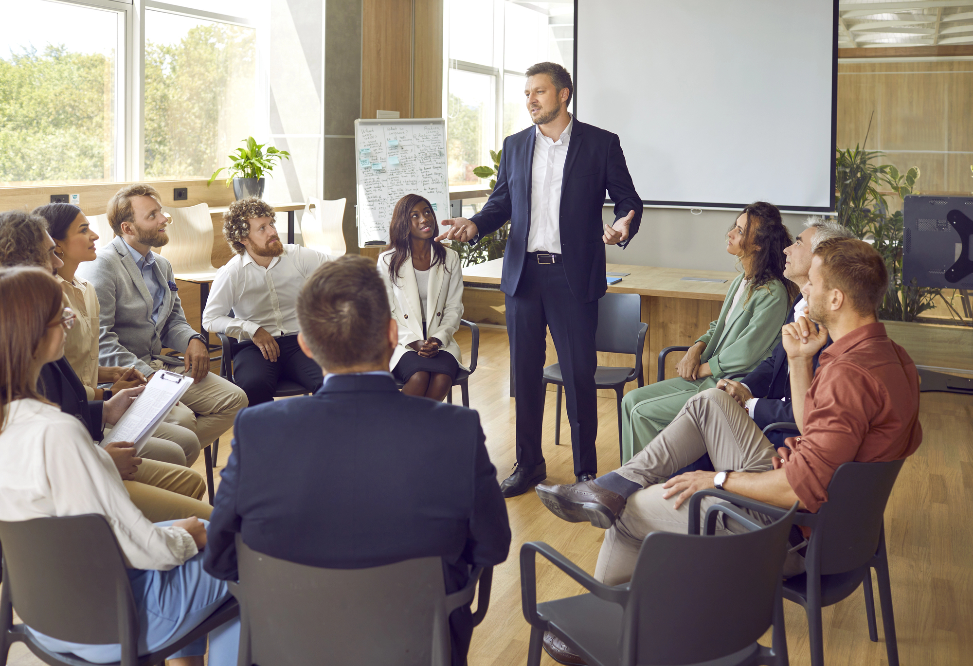 A professional training session led by a confident speaker in a modern office, representing fraud prevention expertise